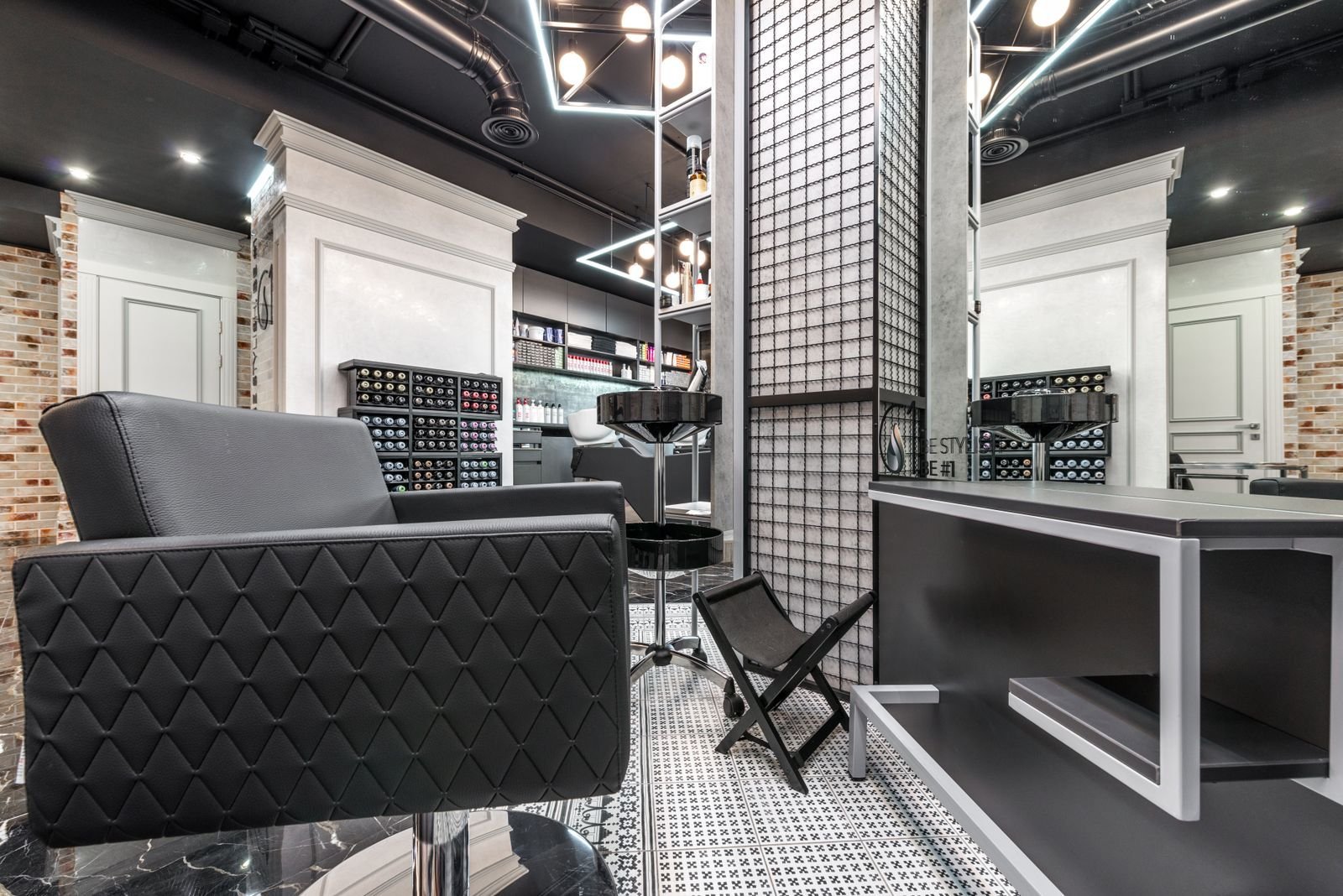 Fauteuil de coupe noir matelassé devant un plan de travail de salon